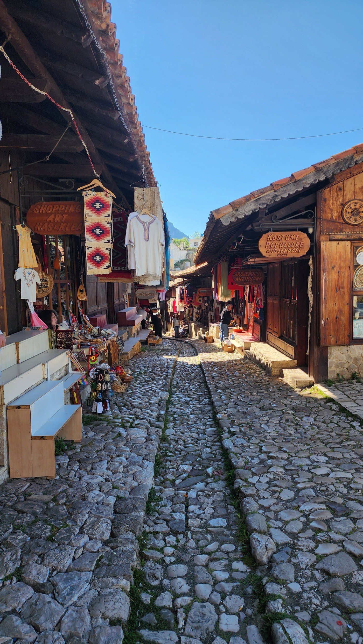 The cobbled lane of the Old Bazaar in Krujë, lined with rugs and traditional crafts
