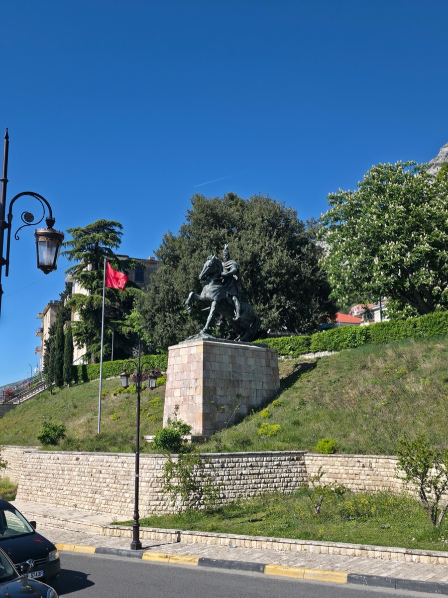 The Skanderbeg equestrian statue in Krujë with the Albanian flag