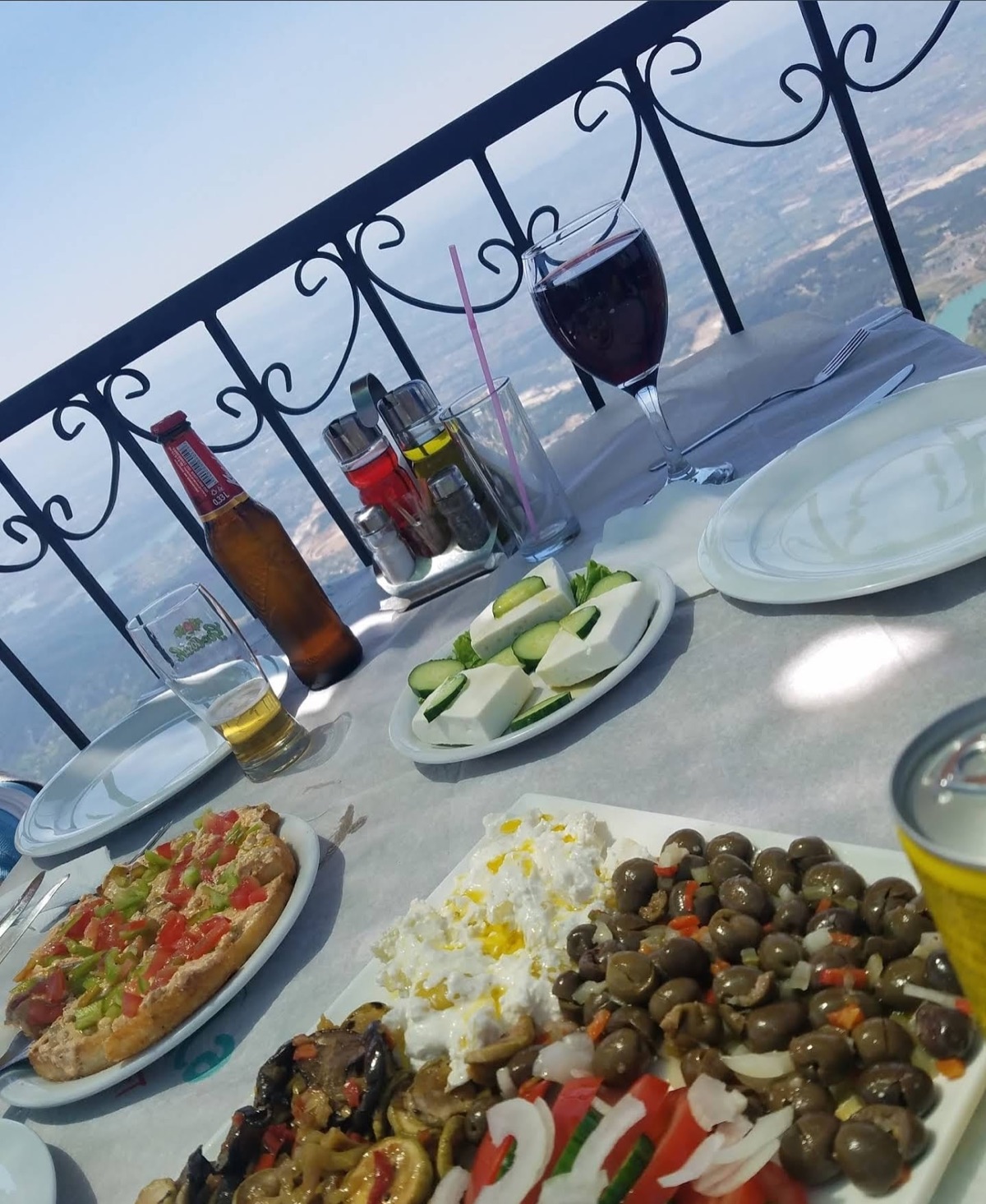 The victory meal on the Zgarë terrace — olives, cheese, wine and grilled dishes overlooking the valley